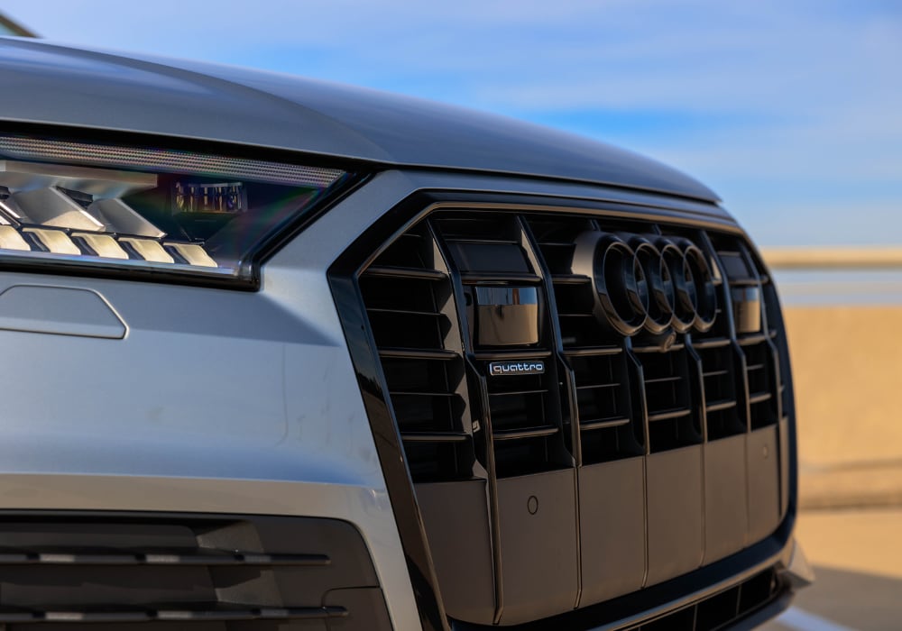 audi-q7-lease-greensboro.png Close up photo of the front grille of an Audi Q7 SUV for sale in Greensboro. The Audi rings logo is visible on the front of the car