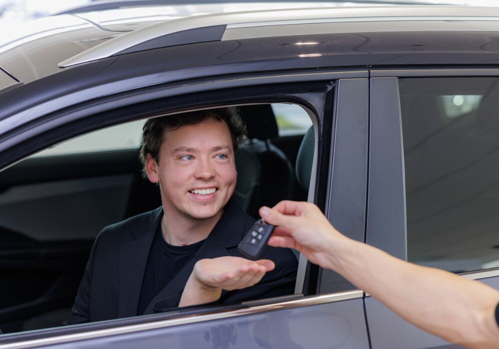 used-cars-for-sale-winston-salem.png A car key is being passed to a customer sitting inside a black used SUV.