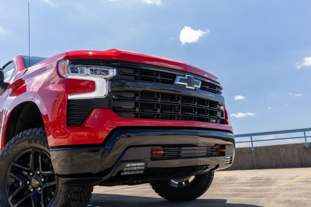 new-chevy-silverado-1500-winston-salem.jpg Front view of red 2024 Chevy Silverado truck for sale parked on top of a parking deck in Winston-Salem, NC
