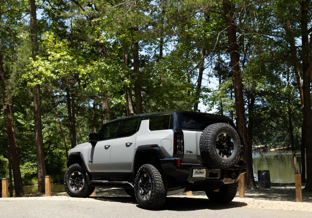 gmc-hummer-ev.png Photo shows a new GMC Hummer SUV EV parked in a paved lot. The image shows the rear of the car, including a spare tire affixed tot he back door
