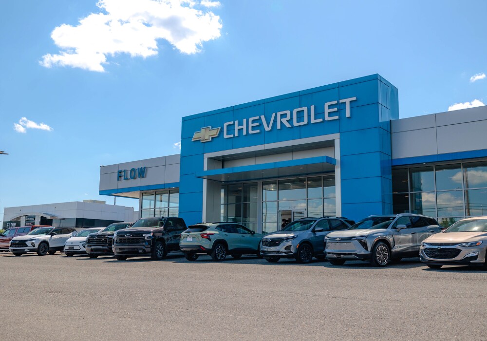 used-chevrolet-for-sale.png Flow Chevrolet Buick GMC dealership with a lineup of Chevy cars and trucks parked out front. There is a blue sky in the background