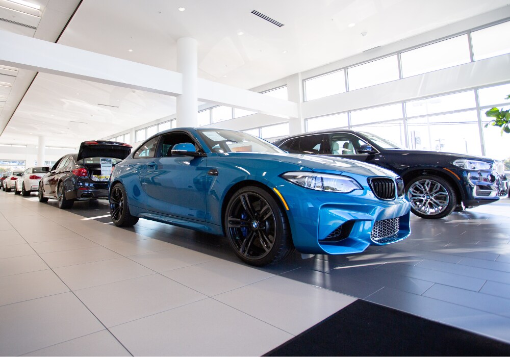 bmw-executive-demo-winston-salem-nc.png BMW Executive Demo cars parked inside the showroom at Flow BMW in Winston-Salem, NC