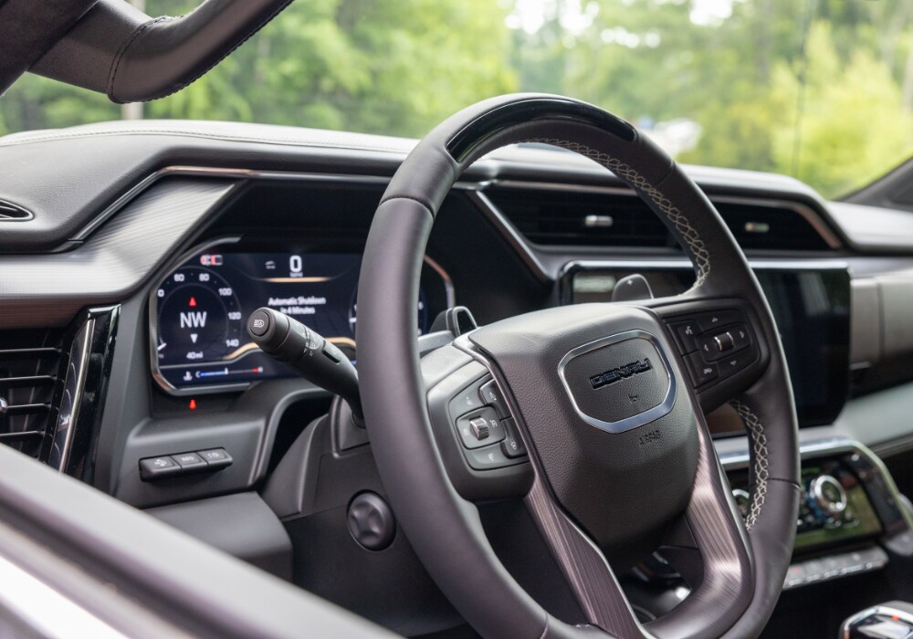 2024-gmc-sierra-1500-interior.png photo taken from the driver's side window of the steering wheel and dash of a 2024 GMC Sierra truck