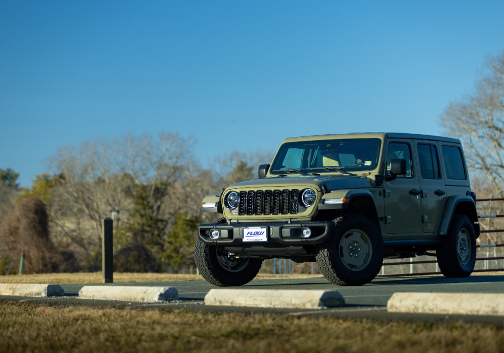 jeeps-for-sale-charlottesville-va.png Green Jeep Wrangler parked in an empty lot with a blue sky in the background