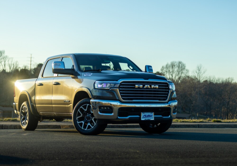 ram-1500-truck-charlottesville.png 2025 RAM 1500 pickup truck parked with a blue sky in the background. The truck is in the color black and the front of the car is facing the camera