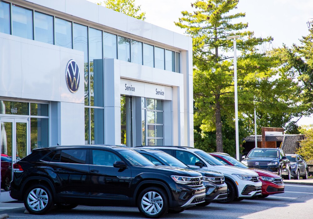 volkswagen-certified-pre-owned-cars-burlington.png Lineup of Volkswagen vehicles parked in front of a Volkswagen dealership in Burlington, NC