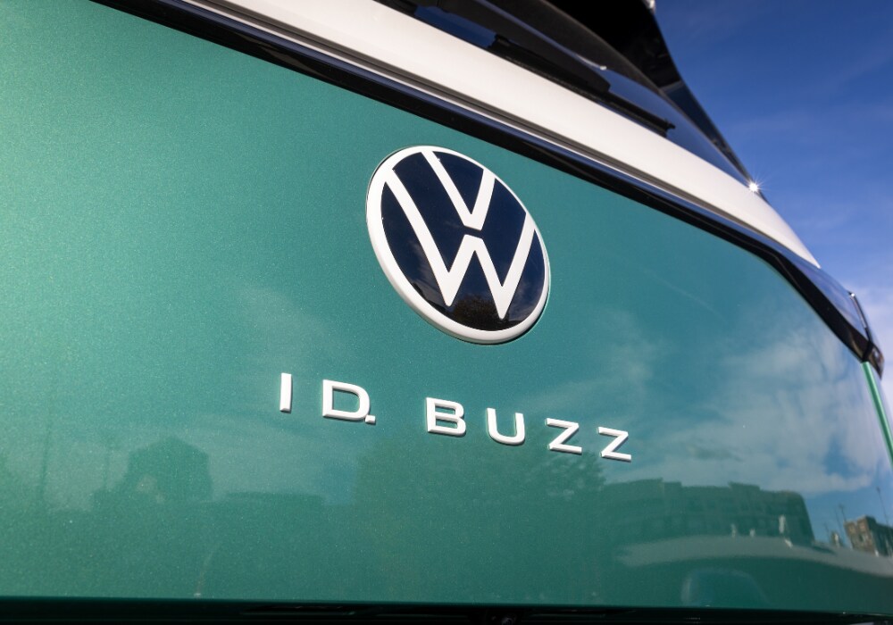 volkswagen-id-buzz.png Photo of the exterior rear of a 2025 Volkswagens ID. Buzz. the car is mostly green with white towards the top. The VW logo is prominent on the back of the car