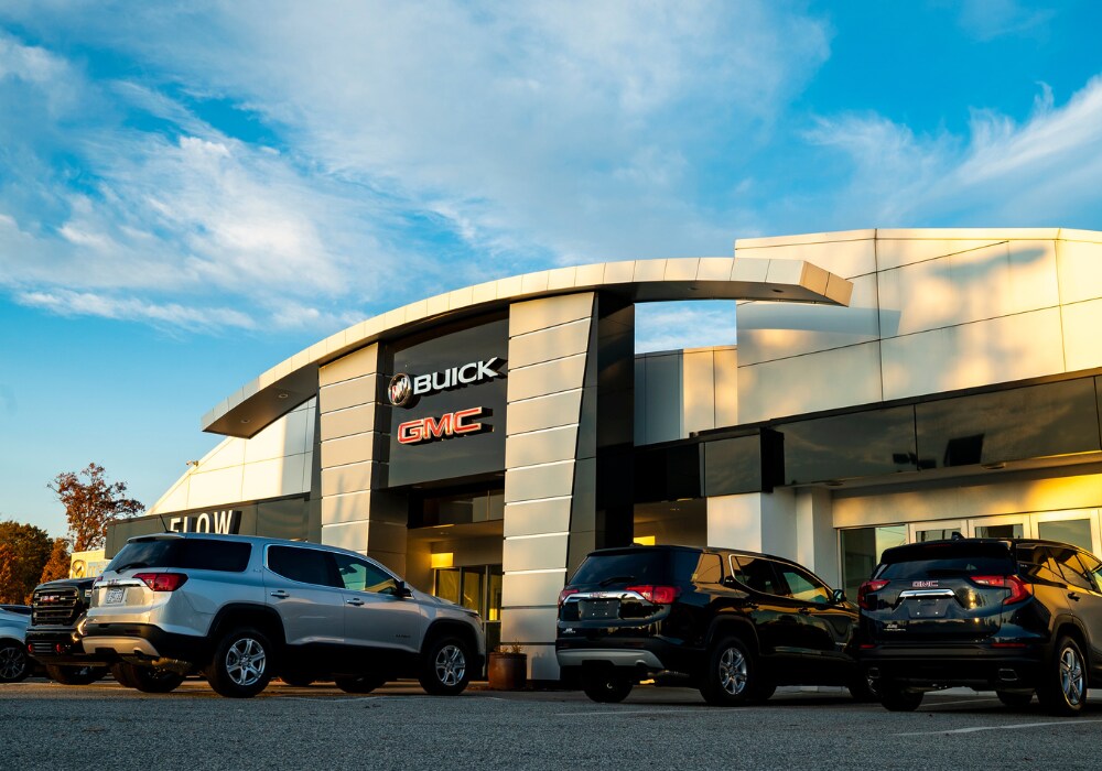 certified-pre-owned-gmc-buick-greensboro.png Storefront of a Buick GMC dealership in Greensboro. There are cars parked in front of the dealership