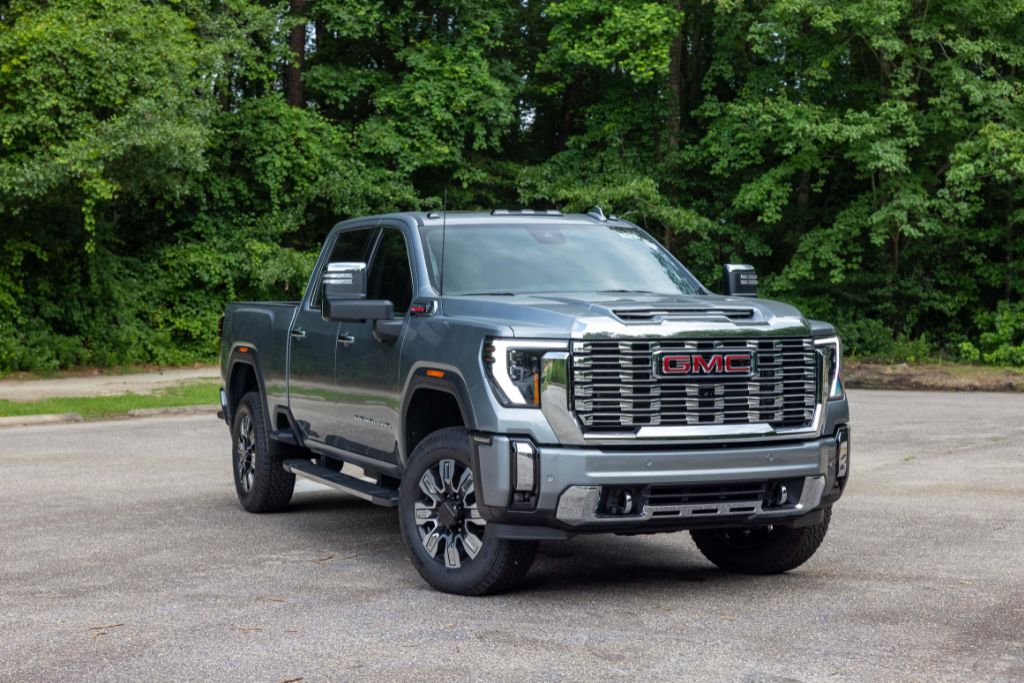 2025-gmc-sierra-2500-for-sale.jpg Gray 2024 Sierra 2500 in Greensboro parked in a paved lot with a wooded background