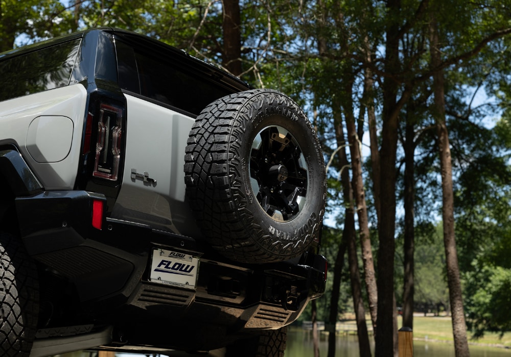 ev-hummer-gmc-rear.png Exterior back shot of a gray 2024 Hummer EV with spare tire attached to the back of the SUV