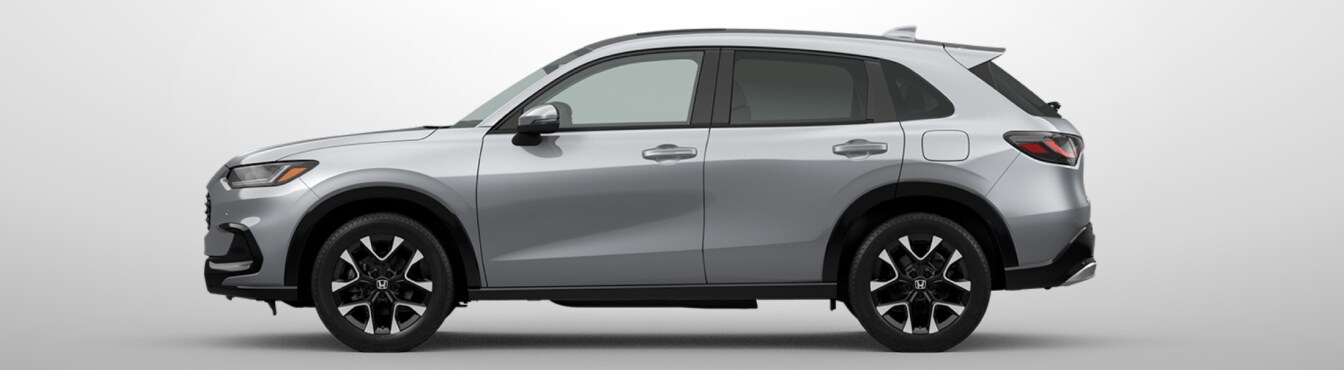 Exterior side view of a 2027 HR-V in Solar Silver Metallic parked agaisnt a light gray background