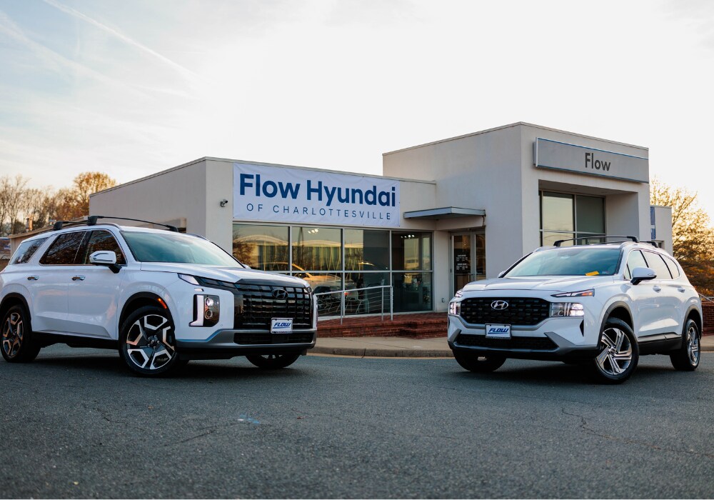 hyundai-cars-for-sale-near-lynchburg.png Two white Hyundai SUVs parked in front of the Flow Hyundai of Charlottesville dealership