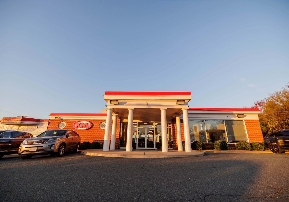 kia-dealership-serving-harrisonburg-va.png Exterior of the Flow Kia of Charlottesville dealership. There are a few Kia cars parked in front of the dealership