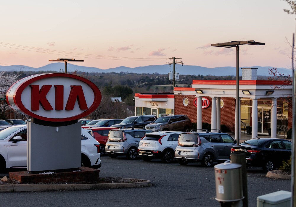 kia-used-cars-charlottesville.png Photo shows the Flow Kia of Charlottesville dealership at sunset with mountains in the background. The dealership lot is full of Kia cars for the sale and the Kia logo is very prominent in the foreground