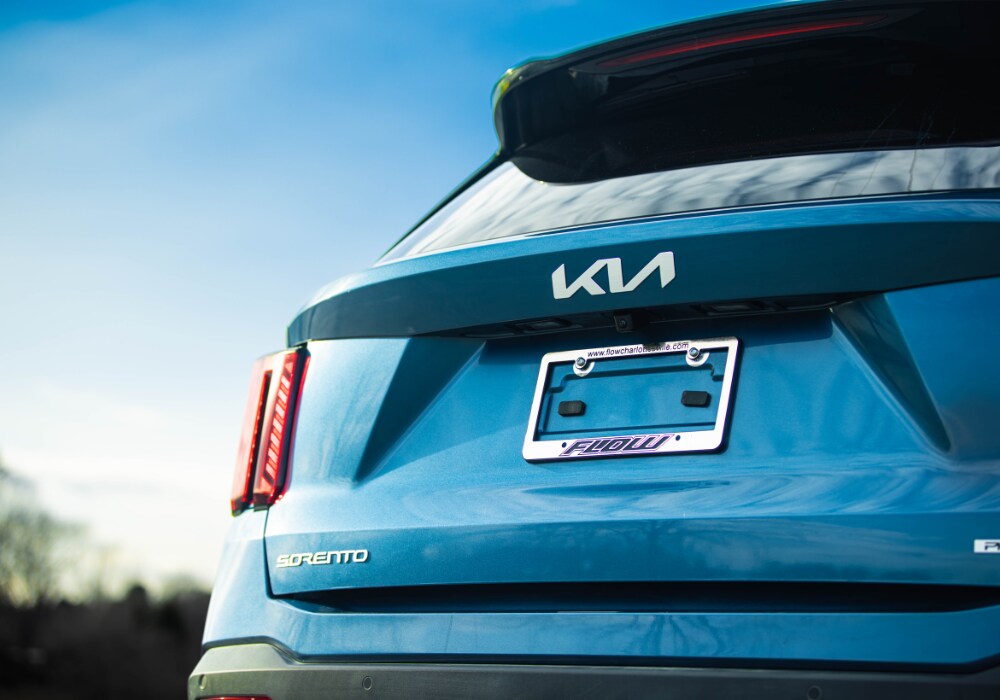 kia-sorento-near-me.png Rear exterior of the 2025 Kia Sorento. The car is blue and the Sorento logo is visible on the back of the car