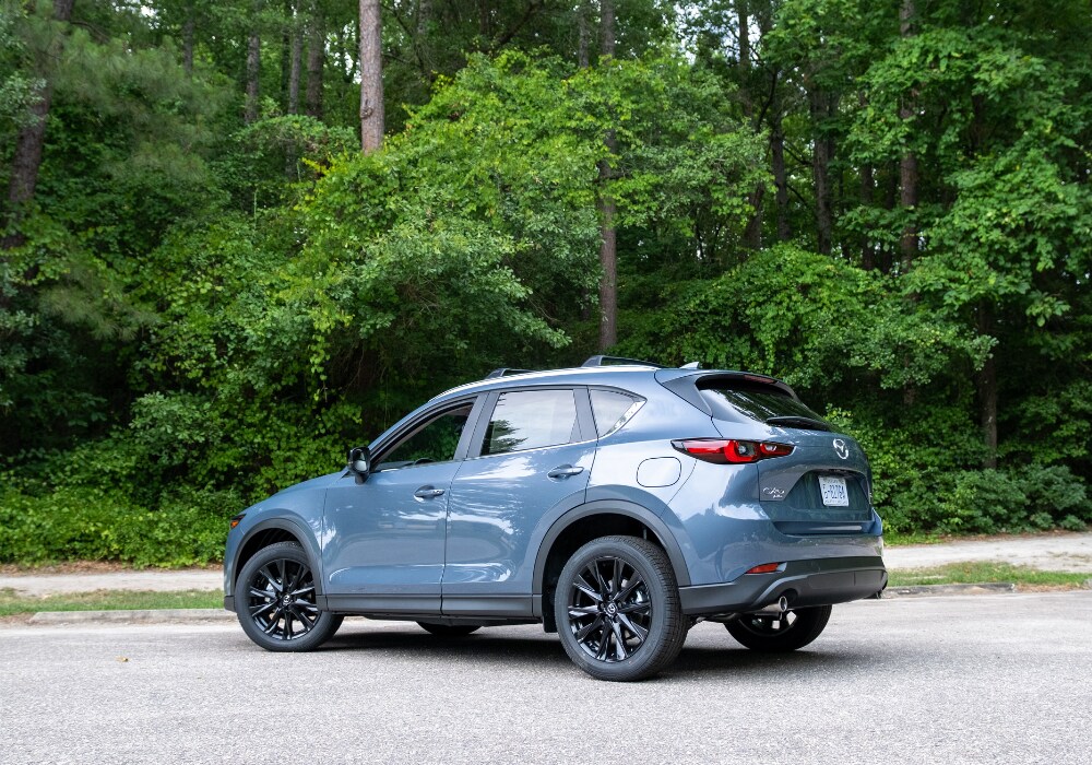 mazda-cx-5-for-sale.png Blue 2025 Mazda CX-5 SUV for sale. The car is parked and the driver's side window is open