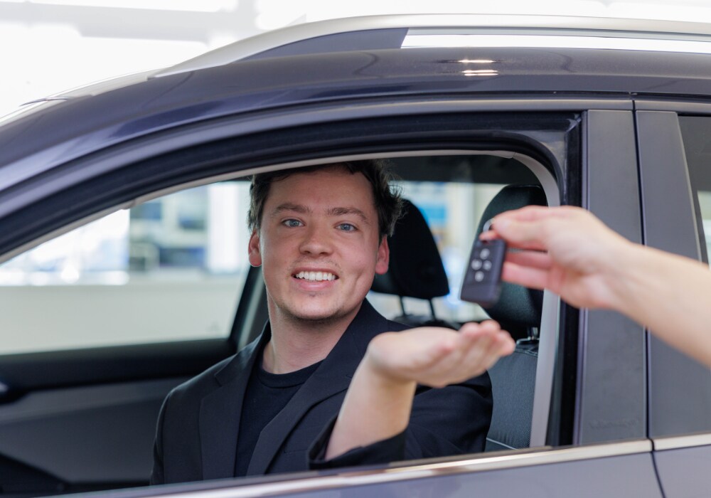 used-mazda-for-sale-fayetteville.png A customer sitting inside of a car at the Flow Mazda of Fayetteville dealership. He is being passed a set of keys and smiling at the camera
