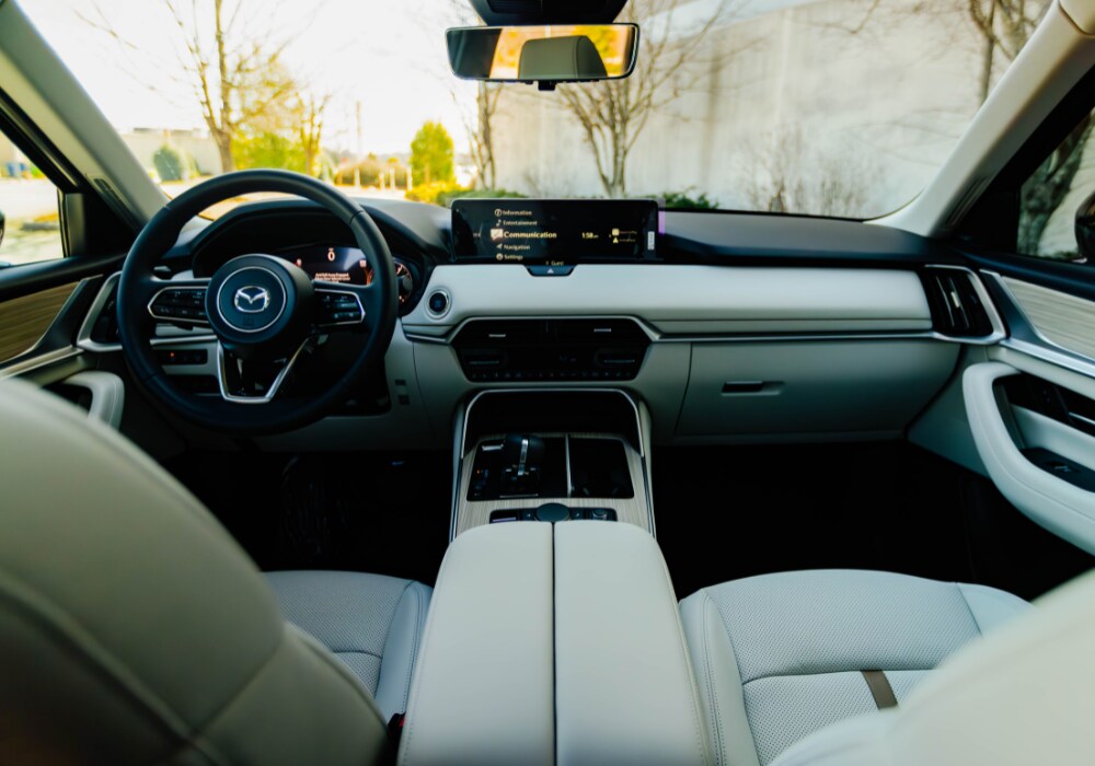 mazda-cx-90-interior.png Interior of the 2025 Mazda Cx-90 showing the front dash. The seats are white leather