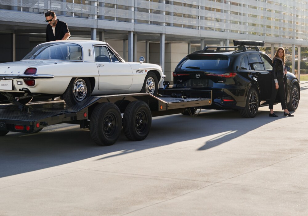 mazda-cx-70-performance.png Black 2025 Mazda CX-70 towing a white sports car