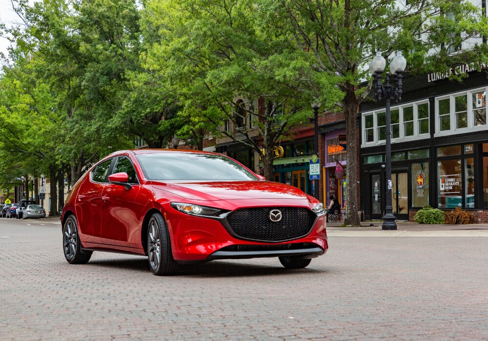 certified-pre-owned-mazda-fayetteville.png Red Mazda sedan parked in a downtown area