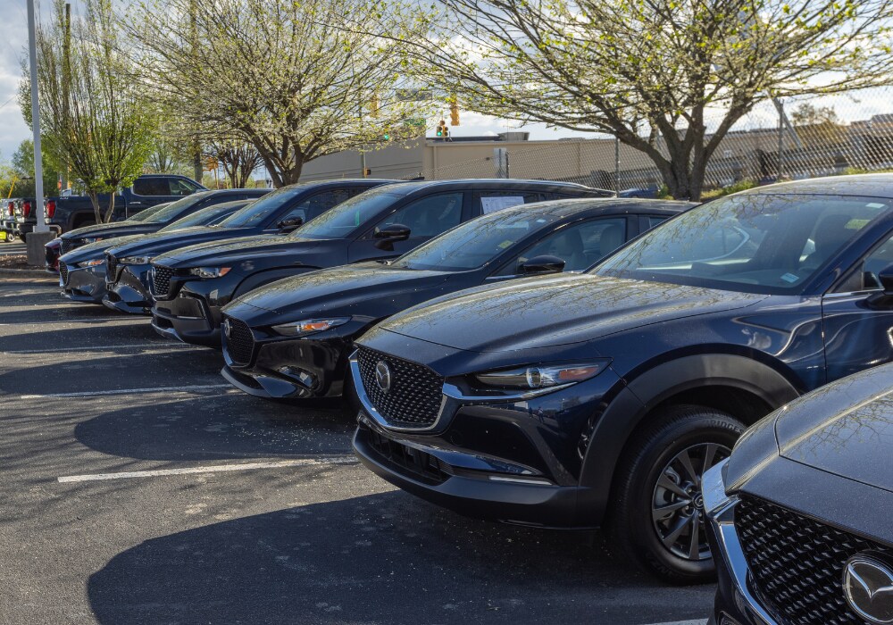 mazda-dealership-near-burlington-nc.png Lineup of Mazda cars for sale parked outside the Mazda dealership in Greensboro