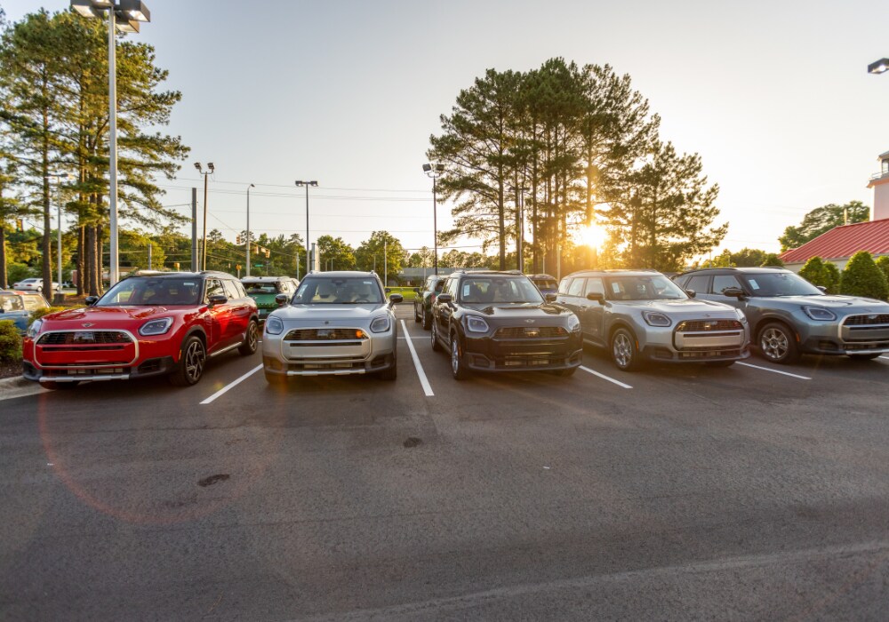 mini-cooper-certified-pre-owned-cars-raleigh.png Lineup of Mini Cooper cars parked in the lot of Flow Mini Raleigh