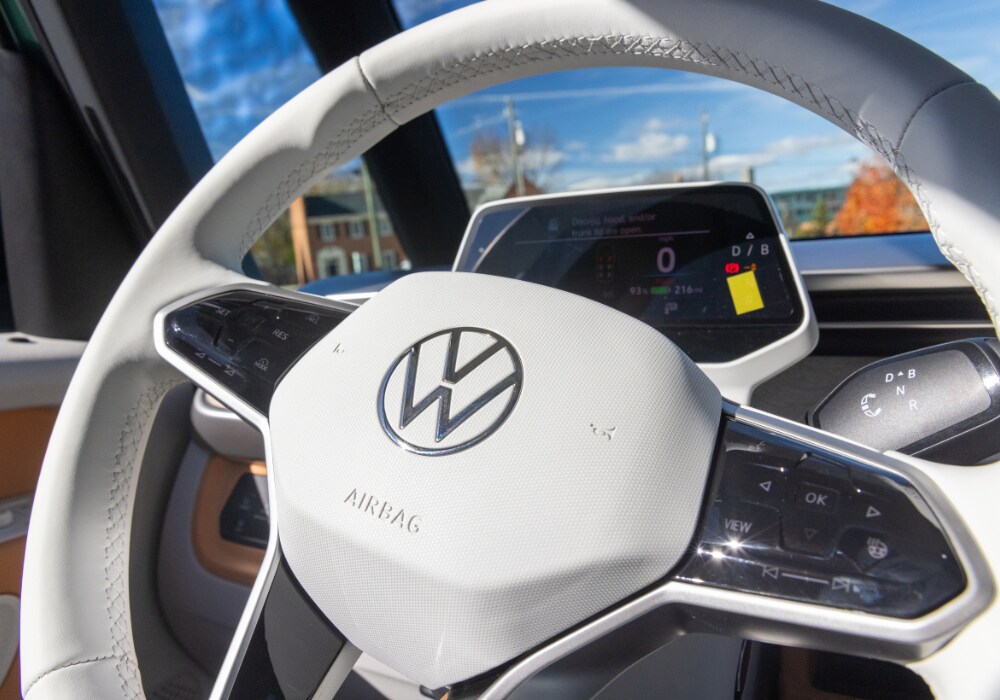 id-buzz-range.png Volkswagen ID. Buzz interior photo showing the steering wheel and front dash. The VW logo is very large on the steering wheel