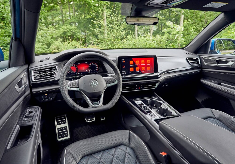 vw-atlas-cross-sport-interior.png Interior of the 2025 Volkswagen Atlas Cross Sport. The dash is gray and the infotainment system is red