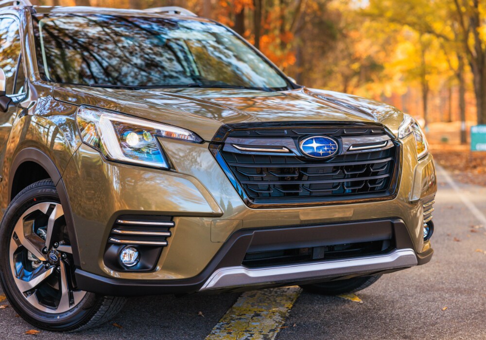 subaru-forester-burlington.png Close up photo of a brown Subaru Forester parked in the middle of the road with trees in the background