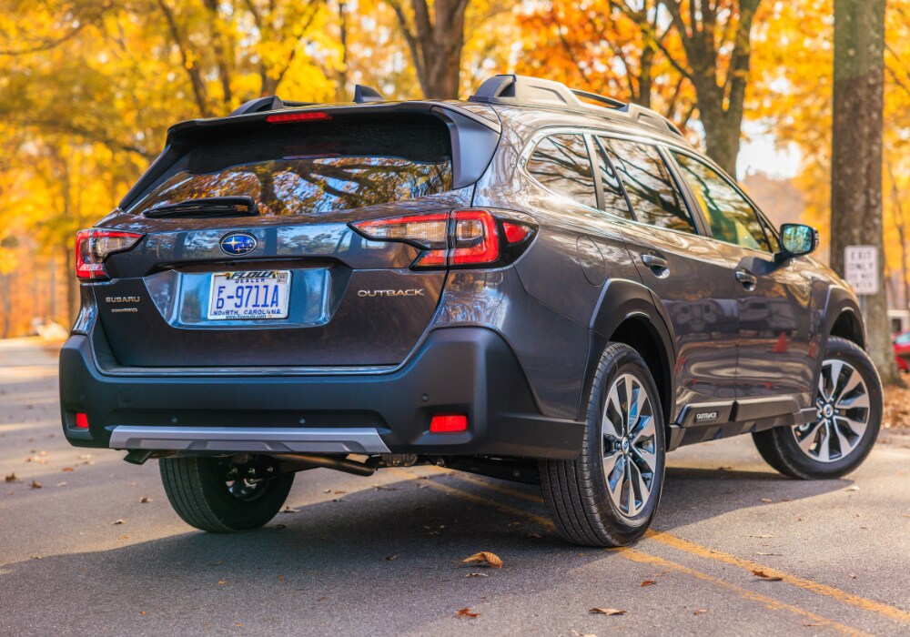 new-subaru-cars-for-sale-burlington.png Exterior rear of a gray Subaru Outback parked on a road with trees in the background