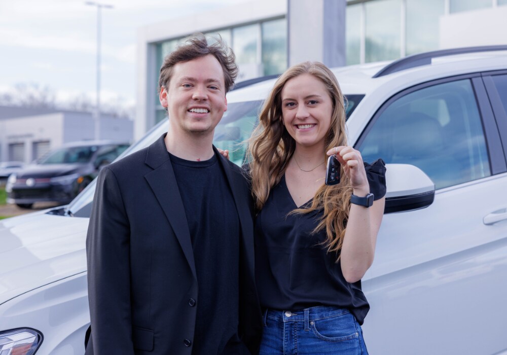 used-cars-for-sale.png A couple stands in front of a car at Flow Toyota of Charlottesville. The woman is holding a set of keys in her hand and both are smiling at the camera