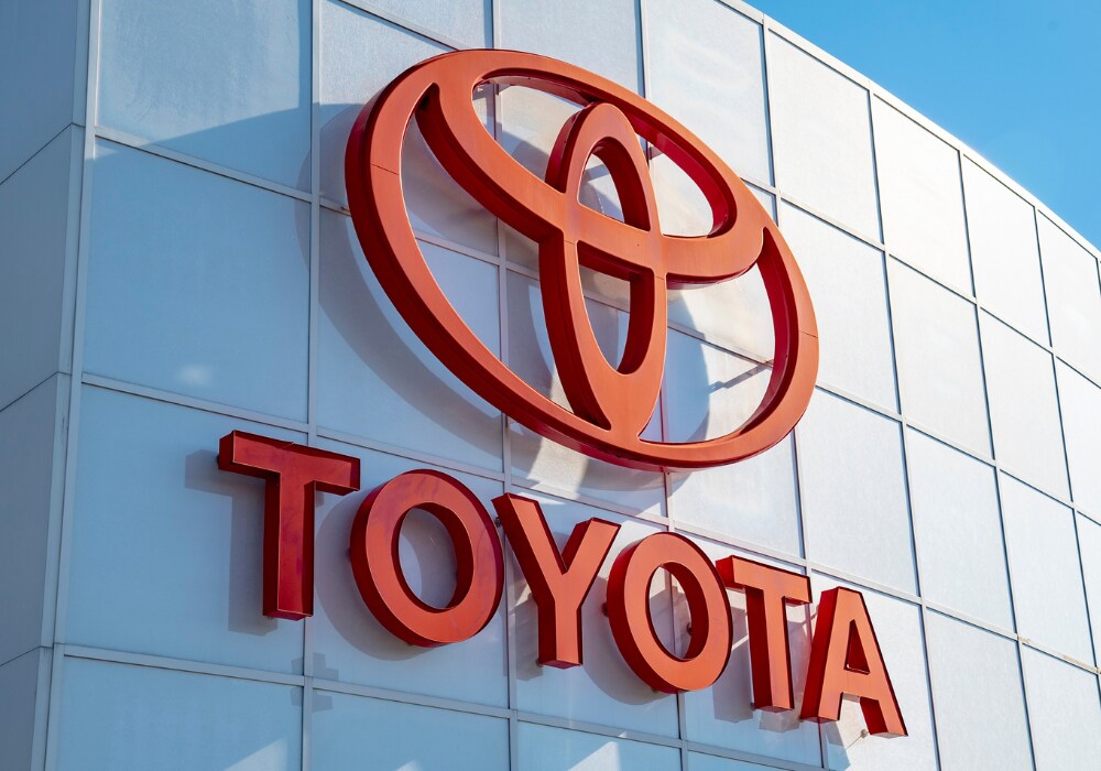 toyota-dealership-near-lake-norman-nc.png Close up phot of the Toyota logo attached to the storefront of the Flow Toyota of Statesville dealership