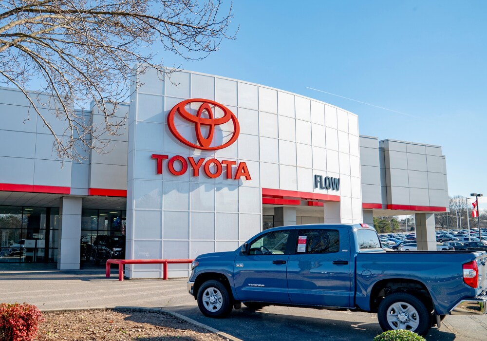 toyota-dealership-statesville-nc.png Flow Toyota of Statesville dealership with a blue Toyota Tundra parked in front of the store.