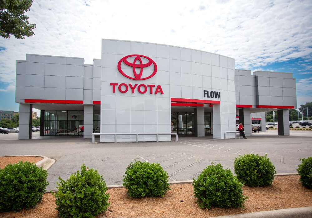 toyota-dealership-near-hickory.png The storefront of the Flow Toyota of Statesville dealership. There is a cloudy sky in the background