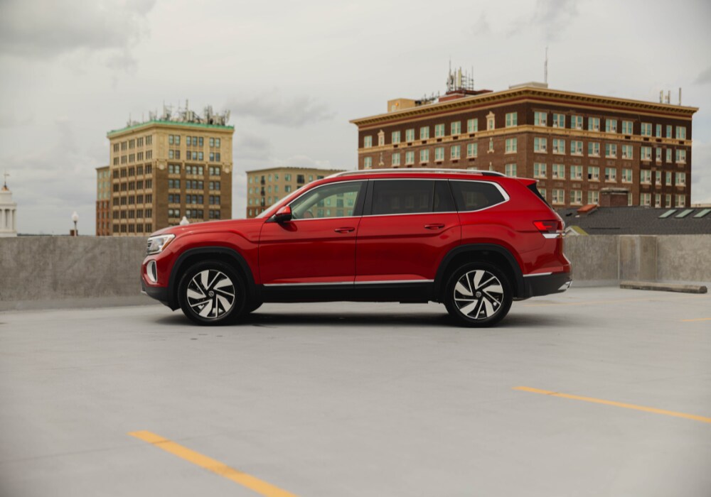 new-volkswagen-atlas-lease-deals.png Exterior driver's side view of a new Volkswagen Atlas for sale parked on a paved surface with tall buildings in the background