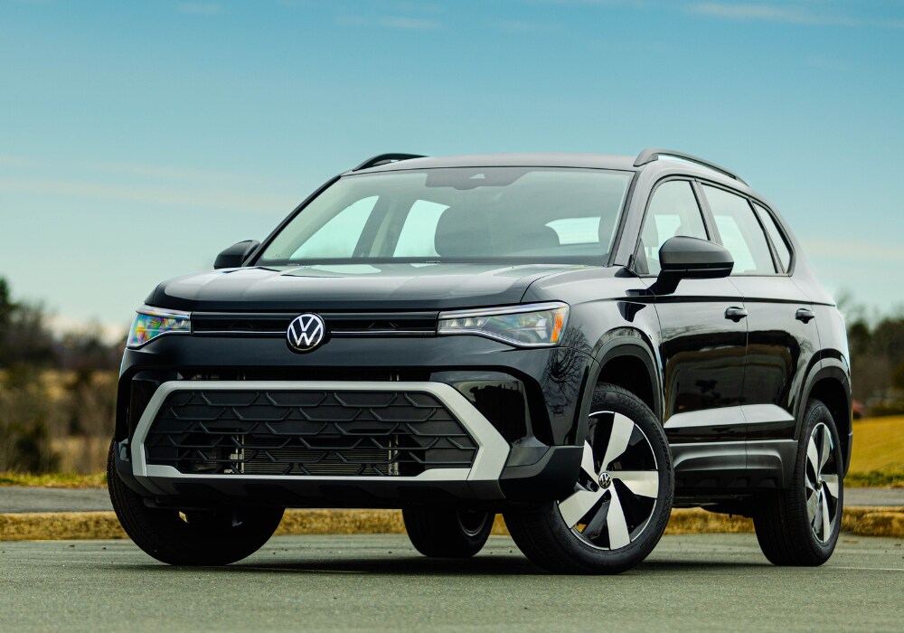 2025-volkswagen-taos.png Black 2025 Volkswagen Taos parked in a paved surface with a blue sky in the background