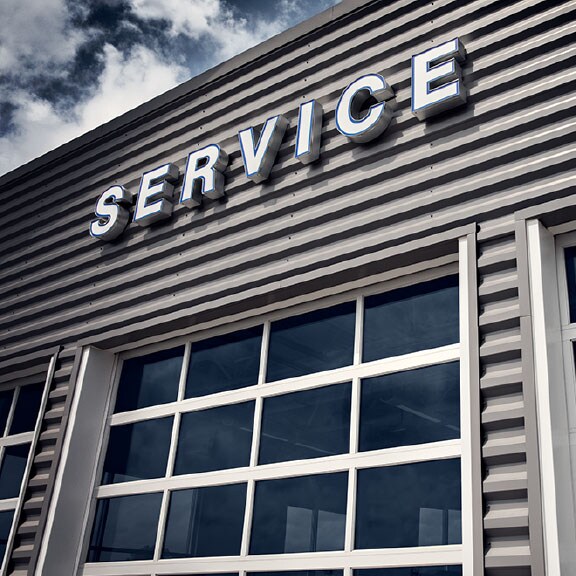 A service sign with white lettering on a gray garage