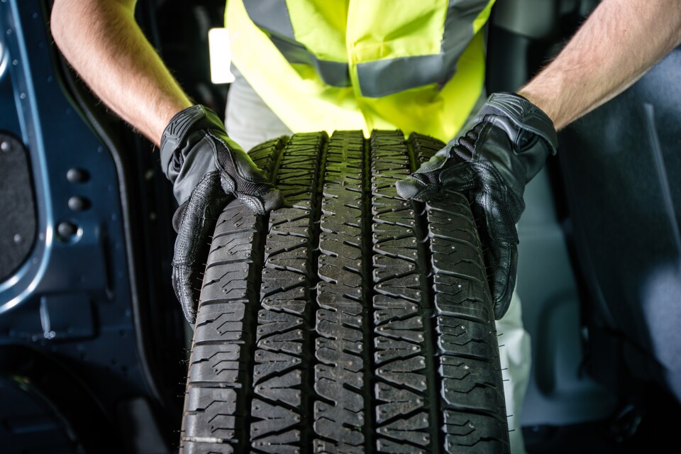Technician Holding a Car Tire