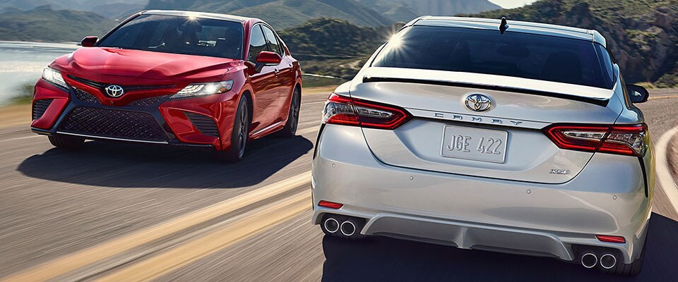 2019 Toyota Camry A red & silver 2019 Toyota Camry passing each other on a road