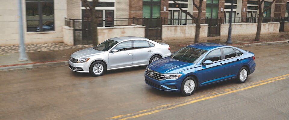 2019 Volkswagen Jetta & 2018 Passat A 2019 Volkswagen Jetta and a 2018 Volkswagen Passat driving down the road side by side