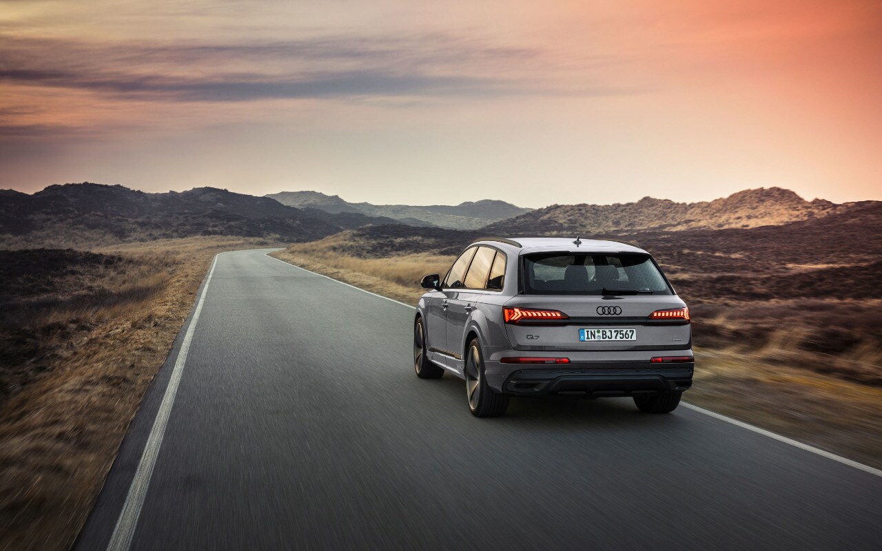 vue latérale arrière d'une Audi Q7 2023 sur une route de campagne au crépuscule