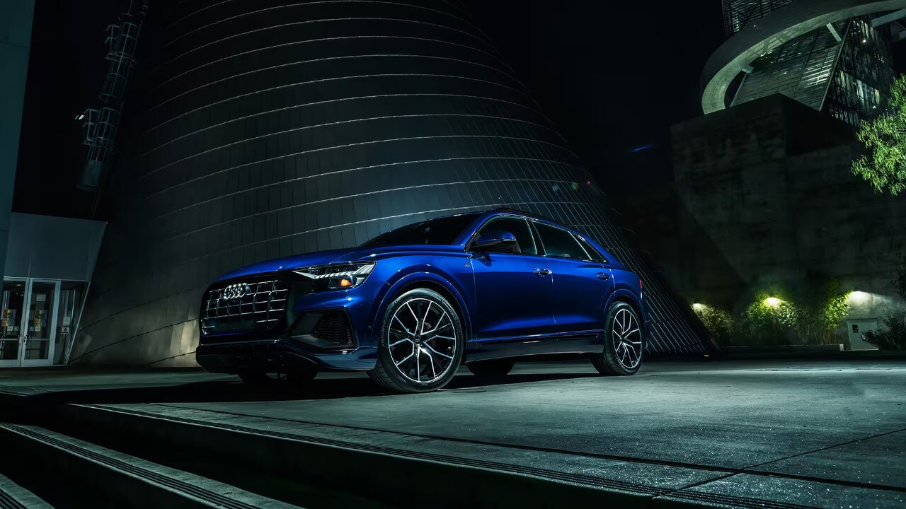 vue latérale avant d'une Audi Q8 2023 devant un bâtiment moderne, la nuit