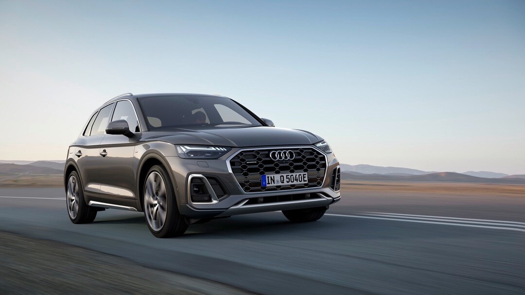 Vue 3/4 avant de l'Audi Q5 Gris Chronos Métallisé roulant sur une route.