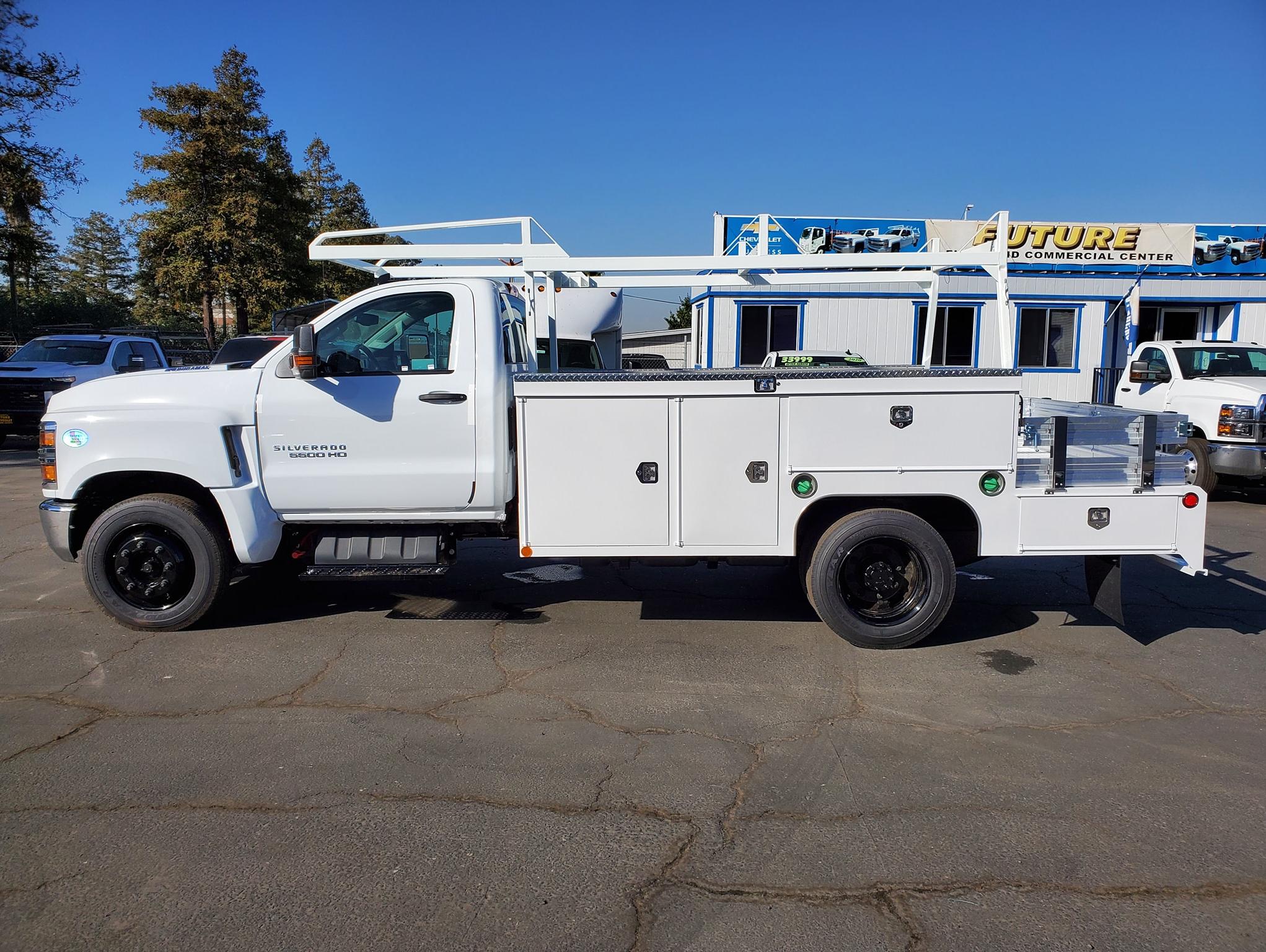 White Chevy Silverado 5500HD with Scelzi Combo body, seen from the side in front of the Future Chevrolet Dealership