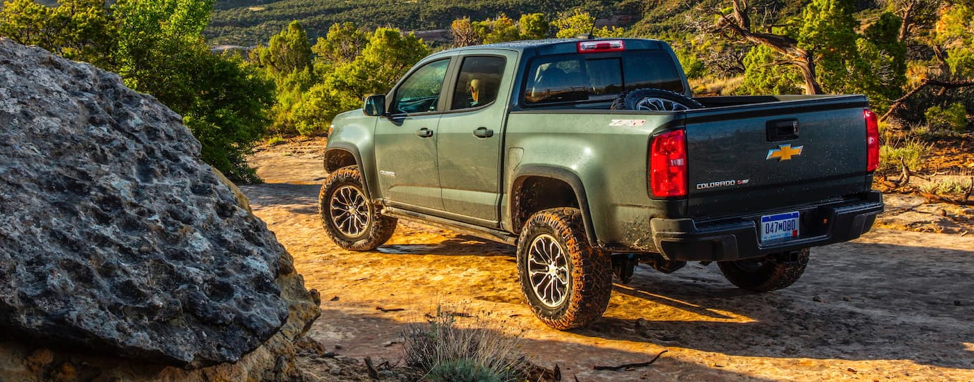used Chevy trucks for sale - 2020 Chevy Colorado Green.jpg A green 2020 Chevy Colorado is shown from a rear angle parked on a dirt trail.