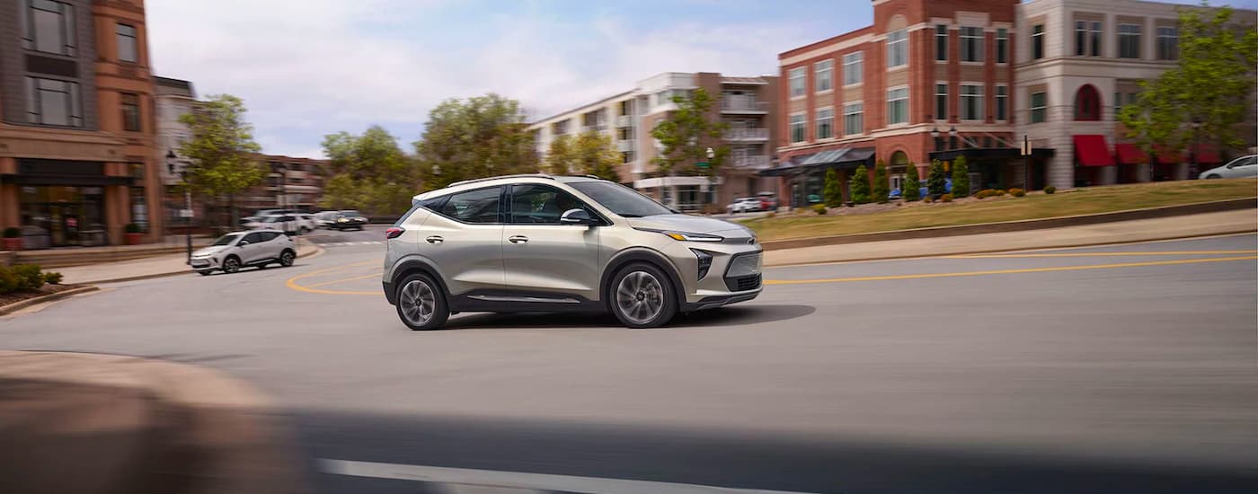 Sacramento Chevy Dealer - 2022 Chevy Bolt EUV - City.jpg A tan 2022 Chevy Bolt EUV driving on a tree-lined city street.