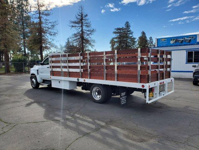 Rear view of a white Chevy Silverado 5500HD with 18 ft Scelzi flat bed and dark wood stake sides