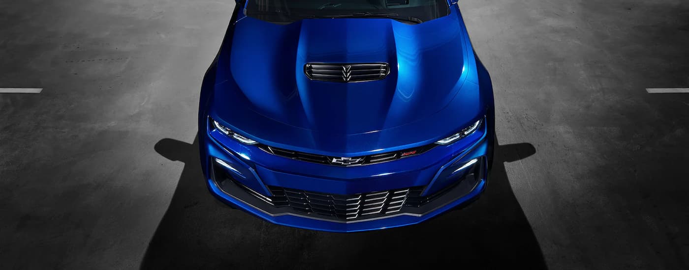 Used Chevy for Sale - 2022 Chevy Camaro SS - Blue (1).jpg A blue 2022 Chevy Camaro SS is shown from the front parked in a dark garage.