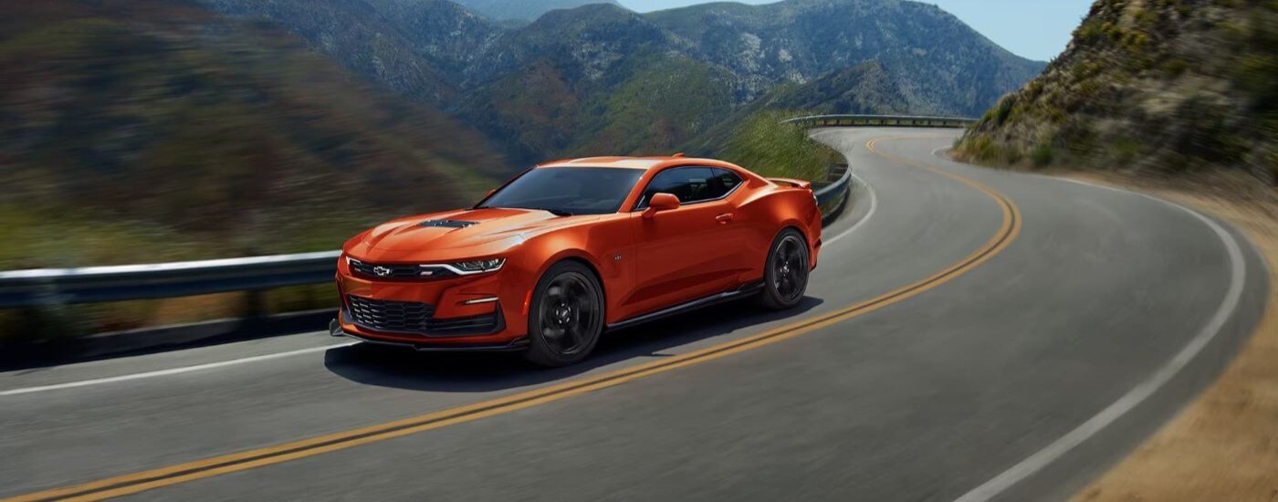 2024 Chevy Camaro 2SS - Mountains.jpg An orange 2024 Chevy Camaro 2SS is shown driving on a winding road.