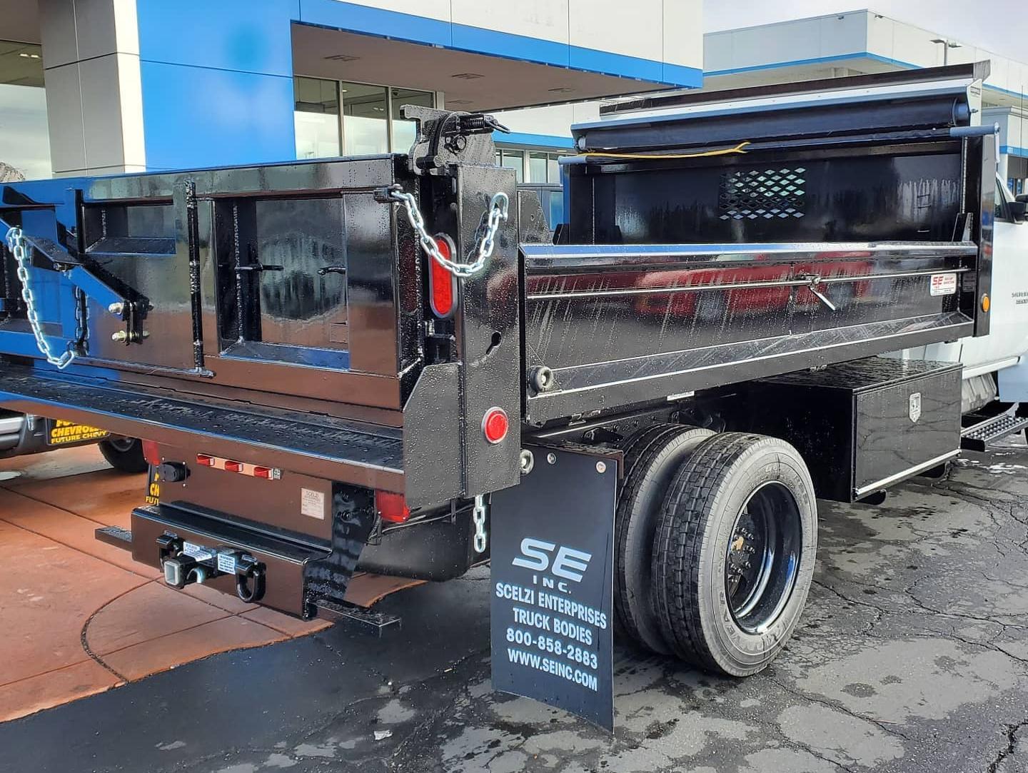 White Chevy Silverado 5500HD with Scelzi Dump Truck body, seen from the back in front of the Future Chevrolet Dealership